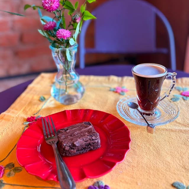 Brownie em prato vermelho com xícara de café coado